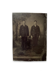 Two Men Twinning with Hats on Ground Tintype
